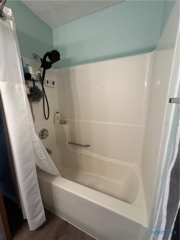 bathroom featuring shower / tub combo and wood finished floors