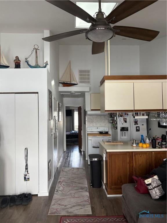 kitchen featuring visible vents, a ceiling fan, light countertops, backsplash, and dark wood-style floors