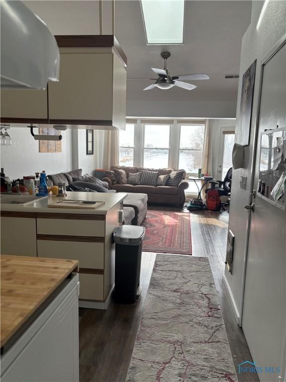 kitchen with visible vents, white cabinetry, open floor plan, and dark wood-style flooring