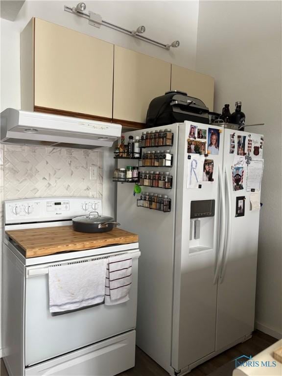 kitchen with white appliances, under cabinet range hood, and decorative backsplash