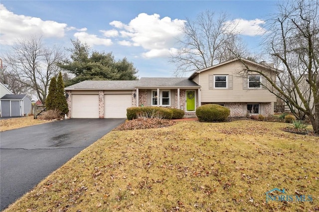 tri-level home featuring aphalt driveway, brick siding, and a garage