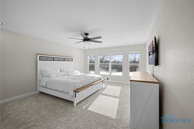 carpeted bedroom with ceiling fan and baseboards