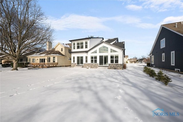 rear view of house featuring stone siding