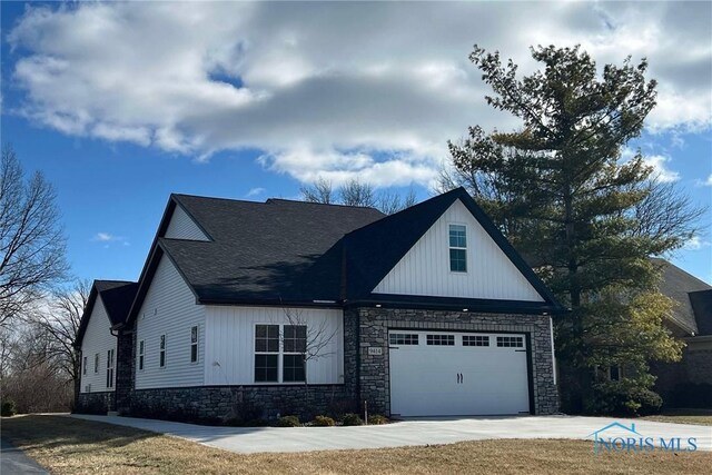 view of front of house featuring a garage, stone siding, driveway, and a shingled roof