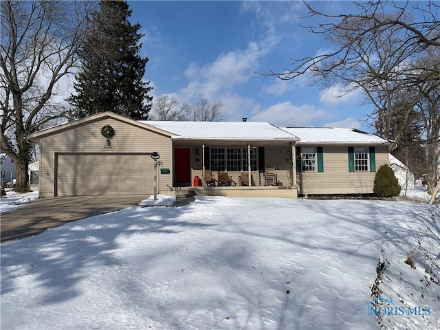 ranch-style house featuring a garage, covered porch, and driveway