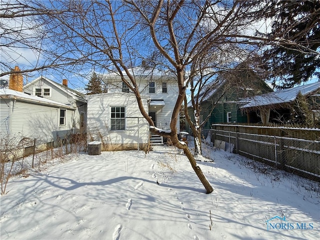 snow covered property featuring fence