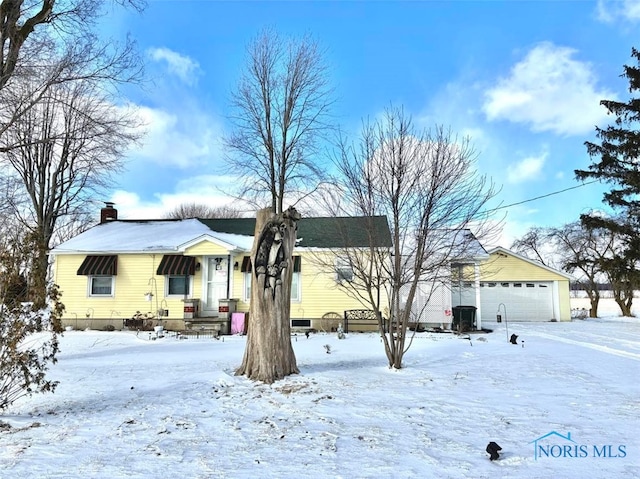 view of front of home with a garage and a chimney