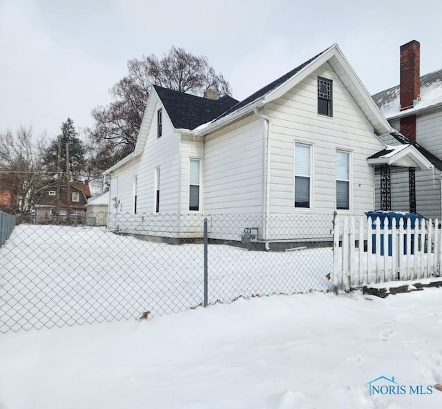 view of snow covered exterior featuring fence