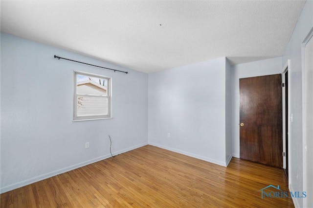 empty room with light wood finished floors and baseboards