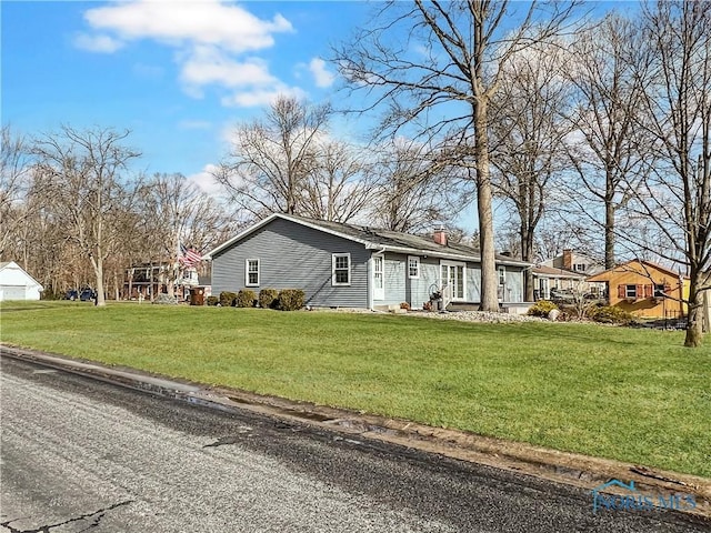 view of front of home featuring a front lawn, a chimney, and a residential view