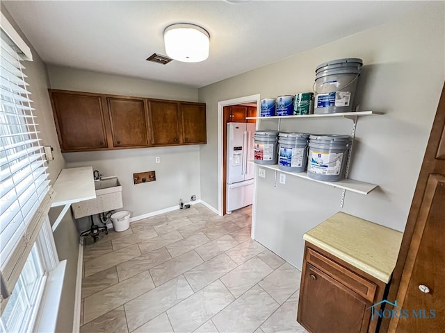 laundry room featuring hookup for a washing machine, baseboards, visible vents, and cabinet space