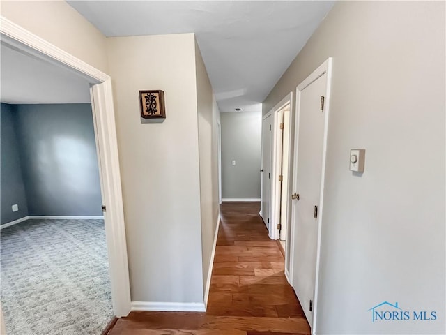 hallway featuring baseboards and wood finished floors