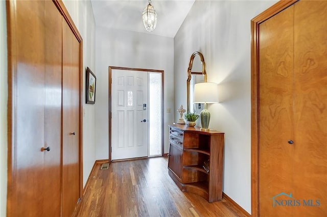 entryway featuring baseboards and wood finished floors