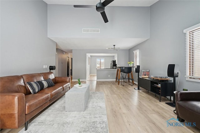 living area featuring ceiling fan, baseboards, visible vents, and light wood-style floors