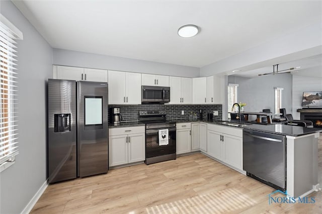 kitchen featuring appliances with stainless steel finishes, white cabinets, and a sink