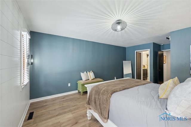 bedroom with light wood-type flooring, visible vents, baseboards, and multiple windows