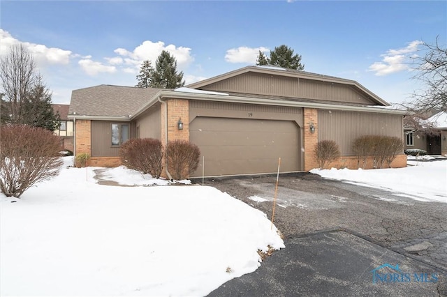 ranch-style house with an attached garage, driveway, and brick siding