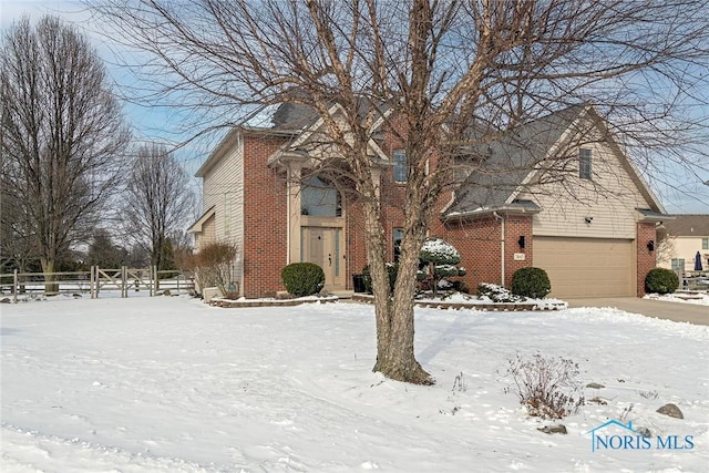 view of front of house featuring a garage, fence, and brick siding