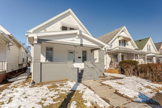 view of front of home featuring covered porch and brick siding