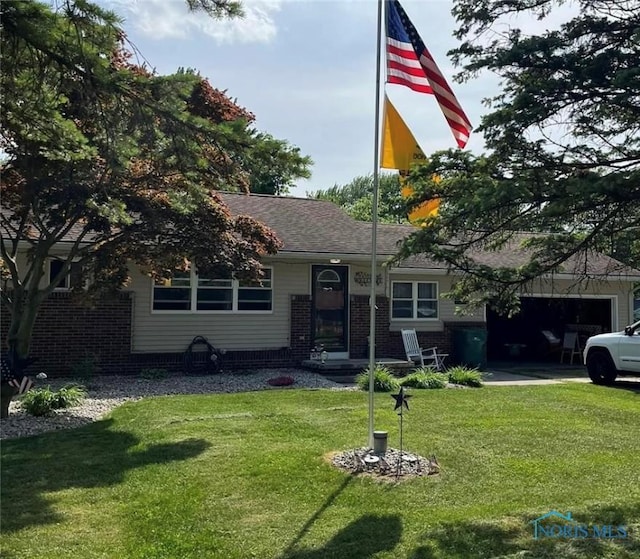 view of front of property with a garage, driveway, a front lawn, and brick siding