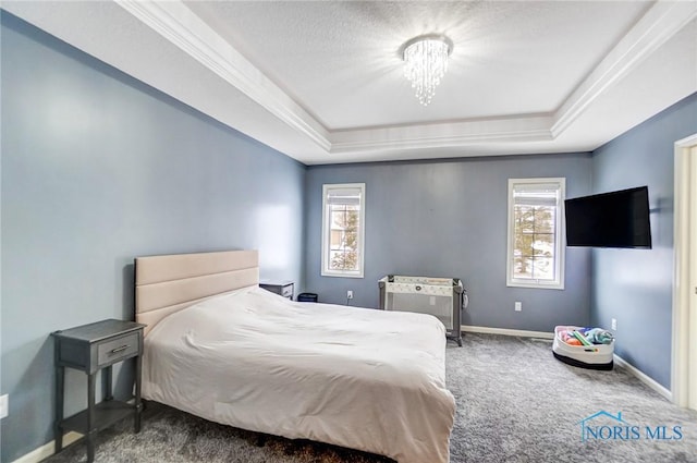 carpeted bedroom featuring multiple windows, baseboards, and a raised ceiling