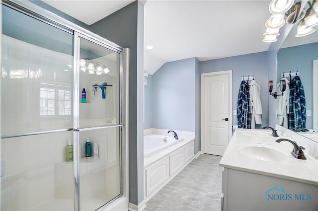 full bath with double vanity, a garden tub, a shower stall, and a sink