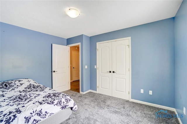 carpeted bedroom with baseboards and a closet