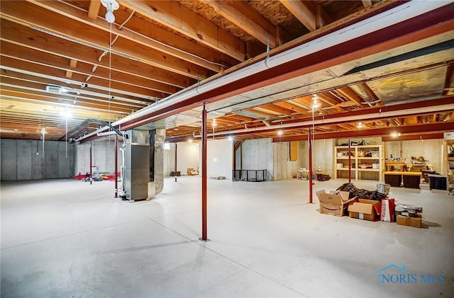 unfinished basement featuring heating unit