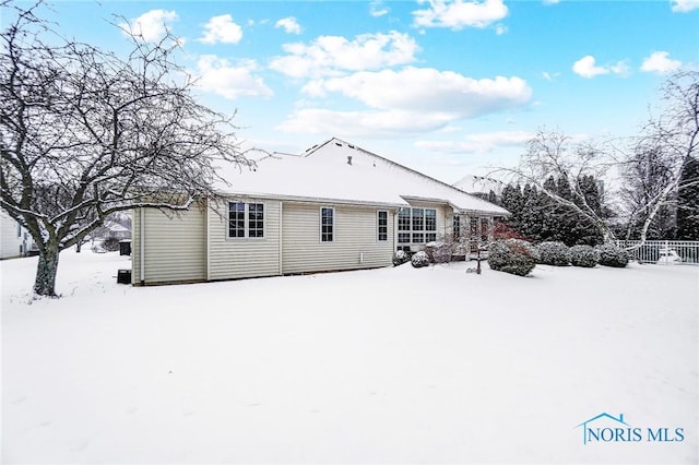 view of snow covered back of property