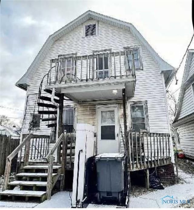 dutch colonial with a balcony and a gambrel roof