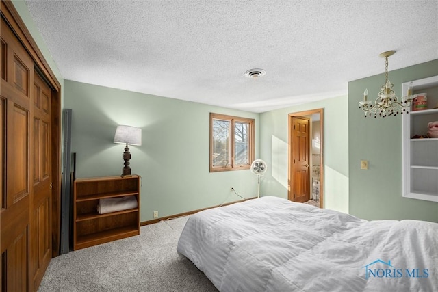 bedroom featuring carpet, visible vents, an inviting chandelier, a textured ceiling, and baseboards