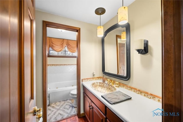 full bathroom with toilet, vanity, and a tub with jets