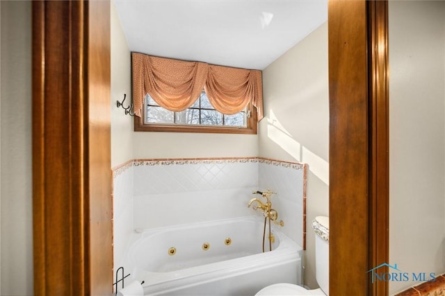 bathroom featuring toilet and a tub with jets