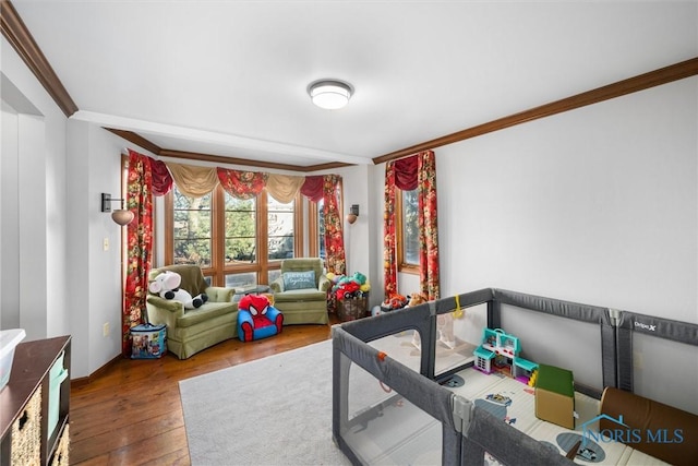 recreation room with hardwood / wood-style flooring and ornamental molding