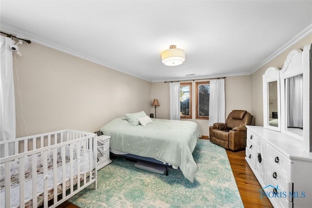 bedroom featuring ornamental molding and wood finished floors