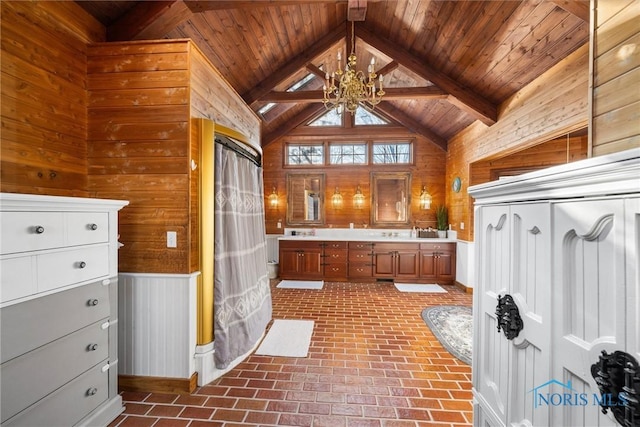 bathroom featuring lofted ceiling with beams, wooden ceiling, wooden walls, and brick floor