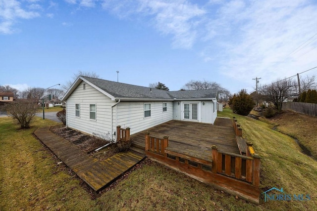 rear view of property with a yard and a wooden deck