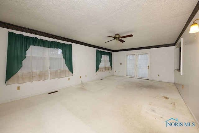 unfurnished room with a textured ceiling, ceiling fan, visible vents, french doors, and crown molding