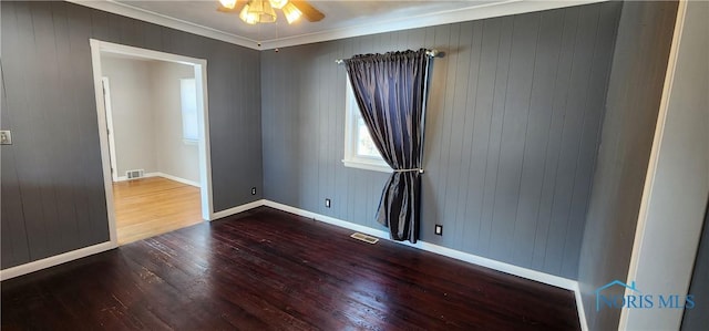 unfurnished room with a ceiling fan, wood finished floors, visible vents, and baseboards