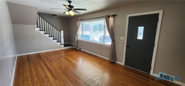 foyer featuring visible vents, stairway, baseboards, and wood finished floors