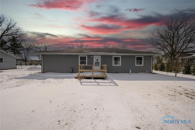 view of snow covered rear of property