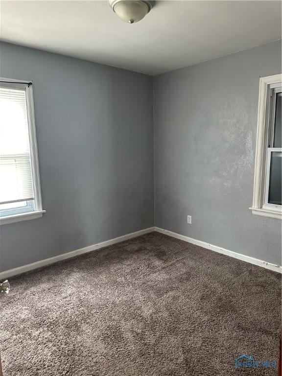 spare room featuring carpet and baseboards