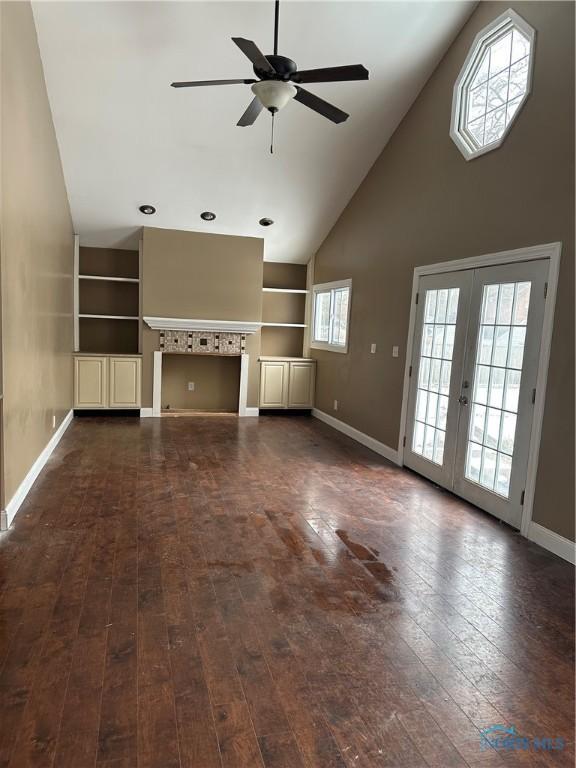 unfurnished living room featuring built in features, french doors, dark wood-style flooring, ceiling fan, and baseboards