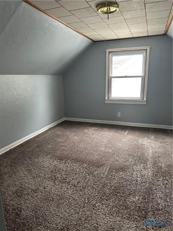 bonus room with carpet floors, baseboards, a textured ceiling, and lofted ceiling