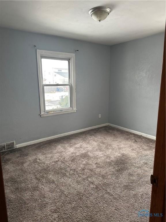 unfurnished room featuring carpet, visible vents, and baseboards