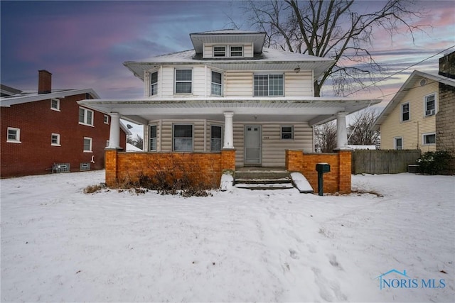 american foursquare style home featuring fence