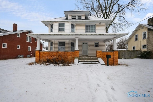 traditional style home featuring covered porch and fence