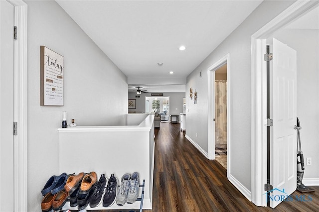 hall featuring baseboards, dark wood-style flooring, and recessed lighting