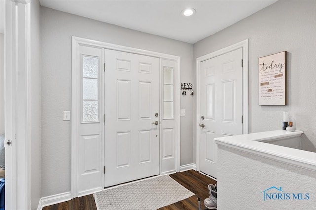 entryway with dark wood-style flooring and baseboards