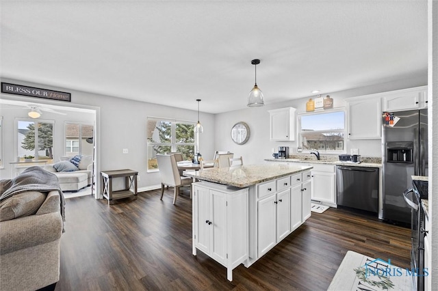 kitchen with dark wood finished floors, open floor plan, white cabinetry, light stone countertops, and dishwashing machine